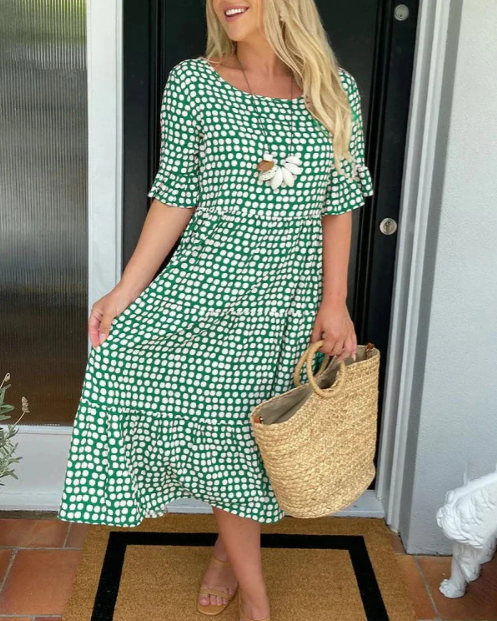 A woman wearing the Angela short sleeve midi dress with a flowing skirt on a warm day.