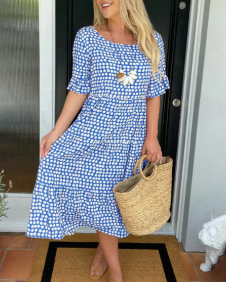 A woman wearing the Angela short sleeve midi dress with a flowing skirt on a warm day.