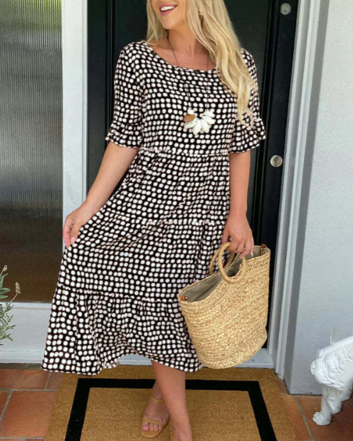 A woman wearing the Angela short sleeve midi dress with a flowing skirt on a warm day.