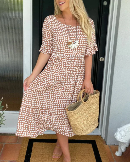 A woman wearing the Angela short sleeve midi dress with a flowing skirt on a warm day.