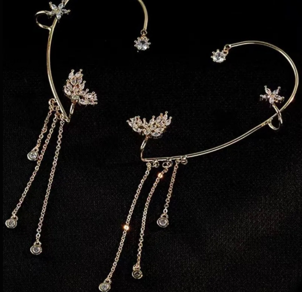 Gold celestial arc earring with a butterfly detail, framing the ear with sparkling luminosity