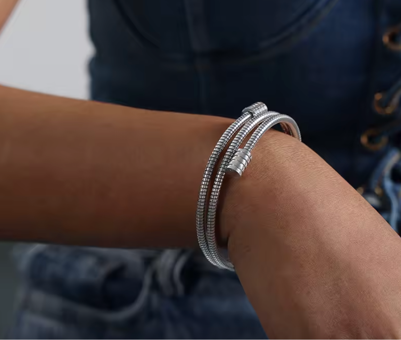 Twisted gold bracelet in gold and silver tones on a plain background