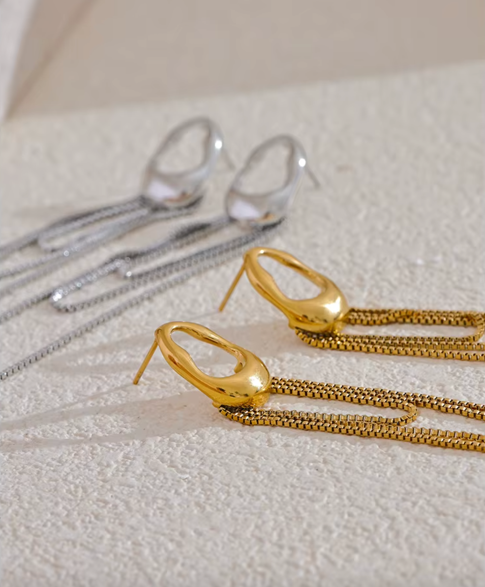 A pair of gold minimalist drop earrings with fine moving chain details