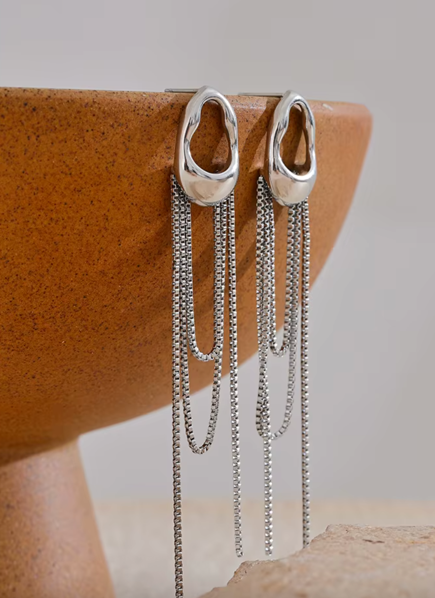 A pair of gold minimalist drop earrings with fine moving chain details