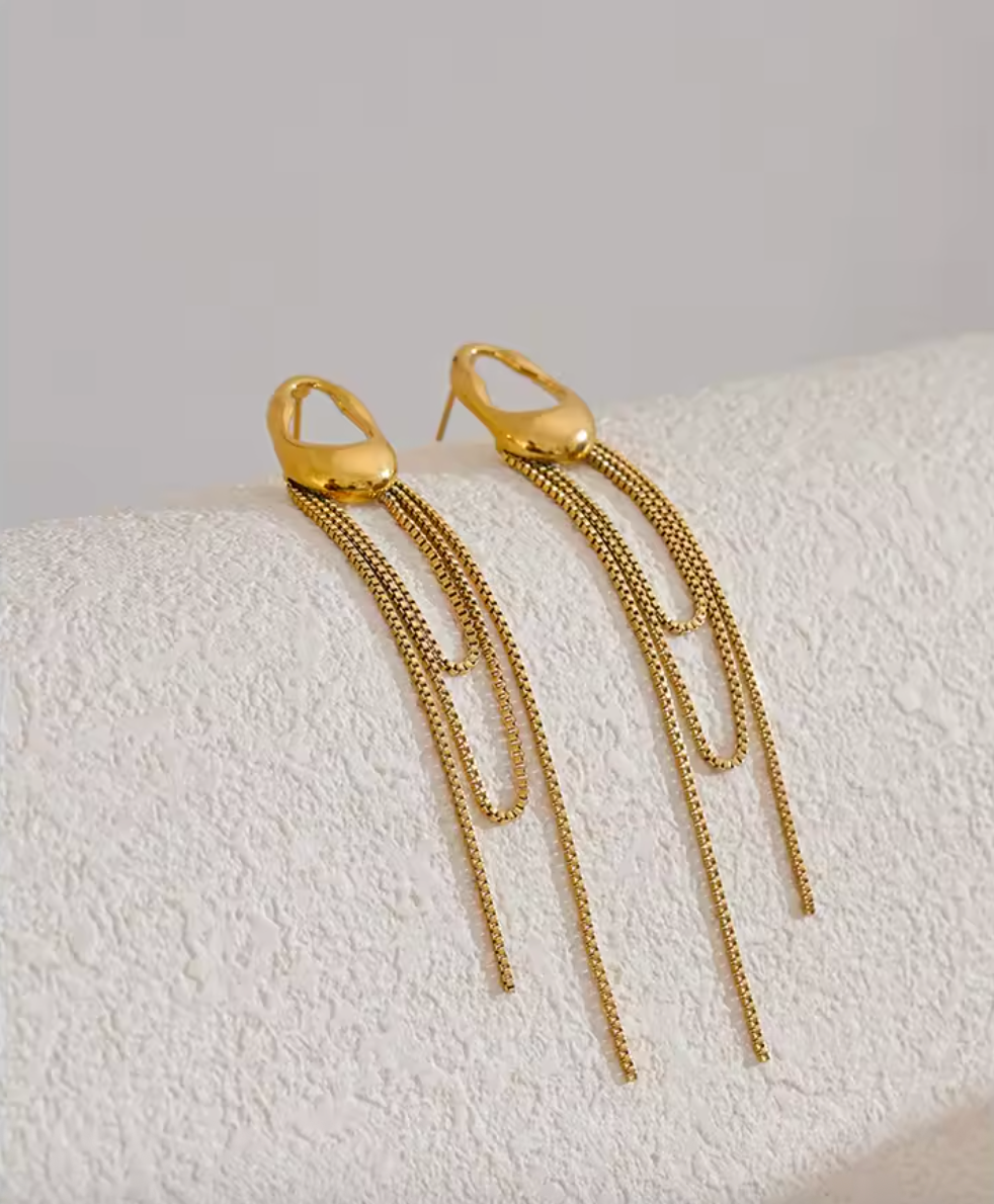 A pair of gold minimalist drop earrings with fine moving chain details