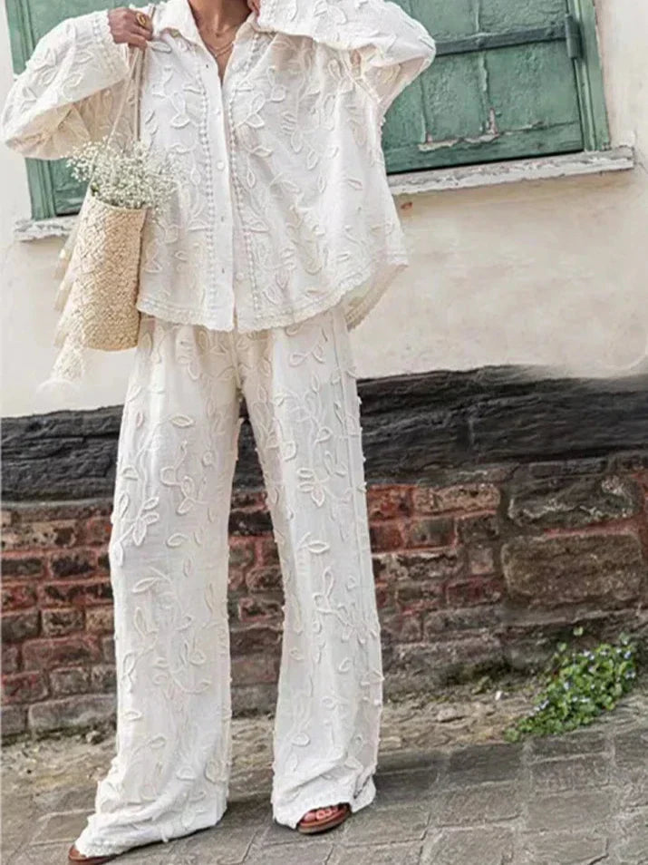 A woman wearing an embroidered relaxed two-piece set with wide trousers
