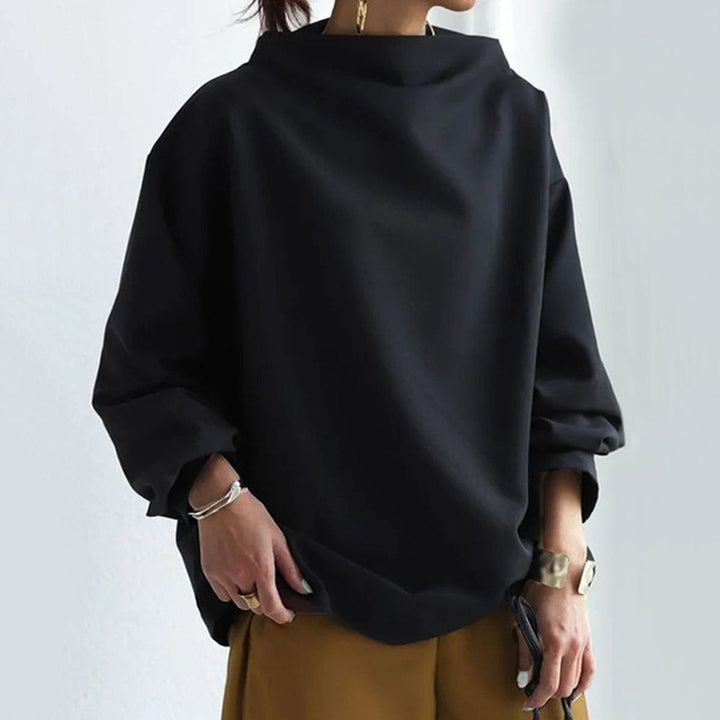 A woman wearing a soft funnel neck jumper styled with jeans for a relaxed elegant look.