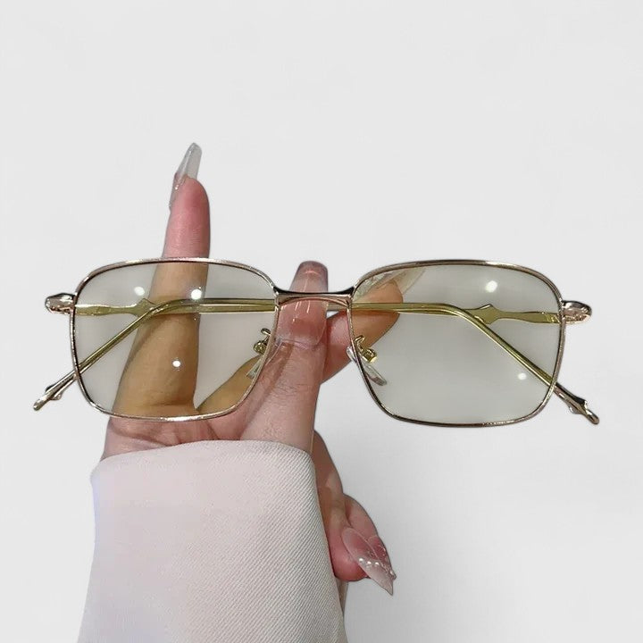 A woman on a sunny street wearing classic square gradient sunglasses, confident and stylish.