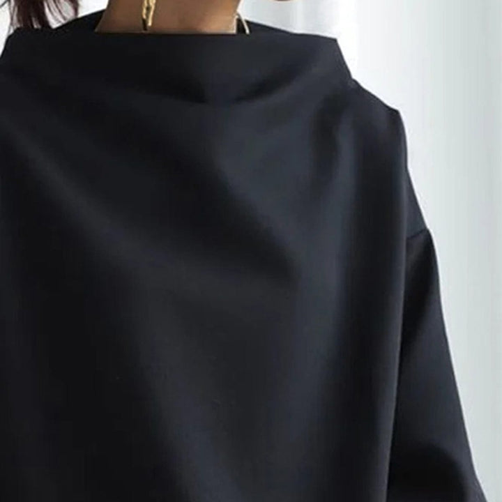 A woman wearing a soft funnel neck jumper styled with jeans for a relaxed elegant look.