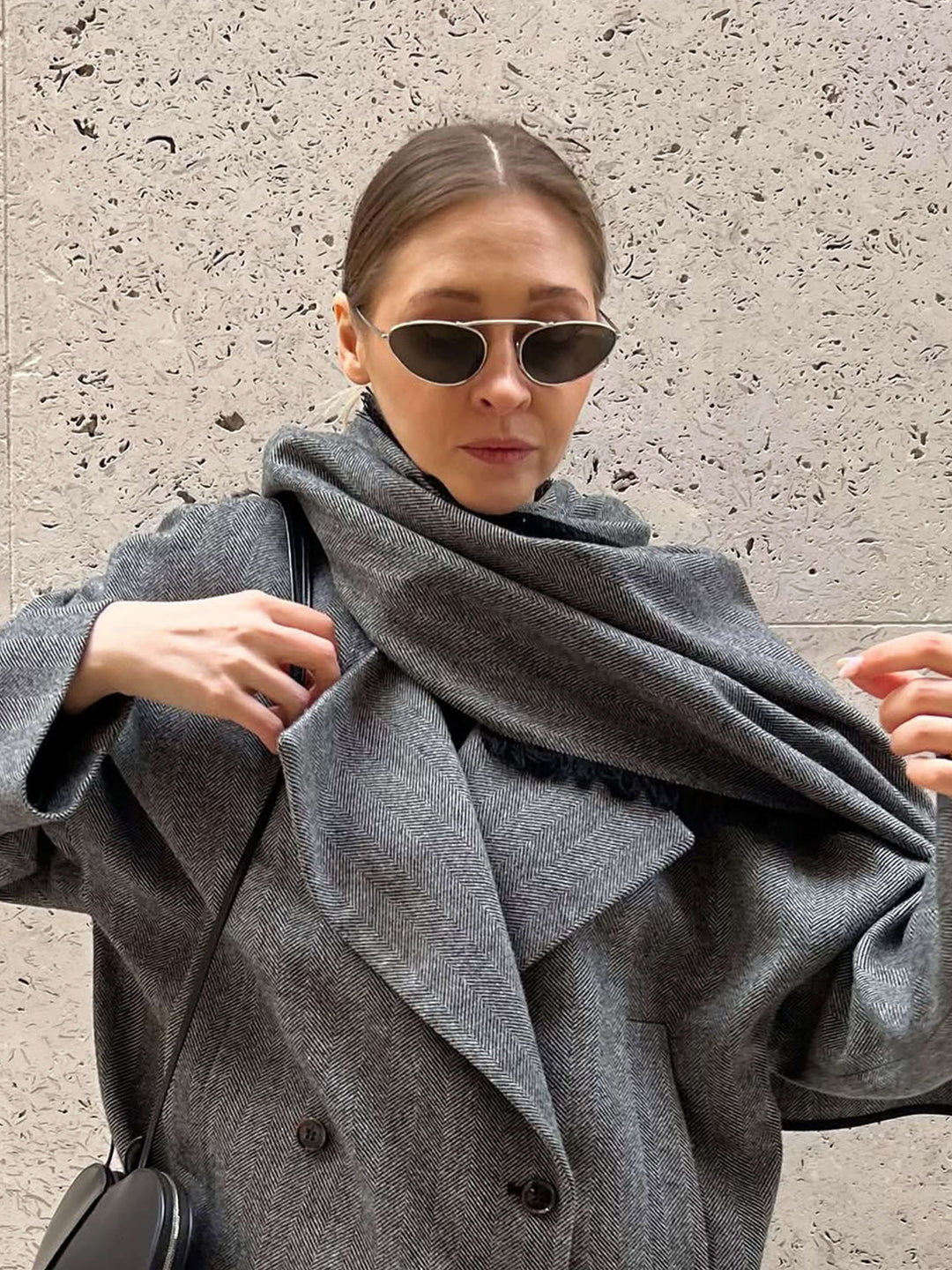 A woman wearing timeless gold-and-black cat-eye sunglasses on an autumn day.