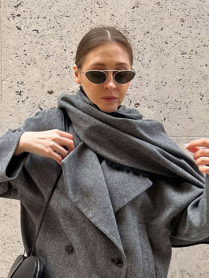 A woman wearing timeless slim black cat-eye sunglasses on an autumn day.