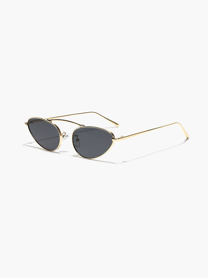 A woman wearing timeless gold-and-black cat-eye sunglasses on an autumn day.