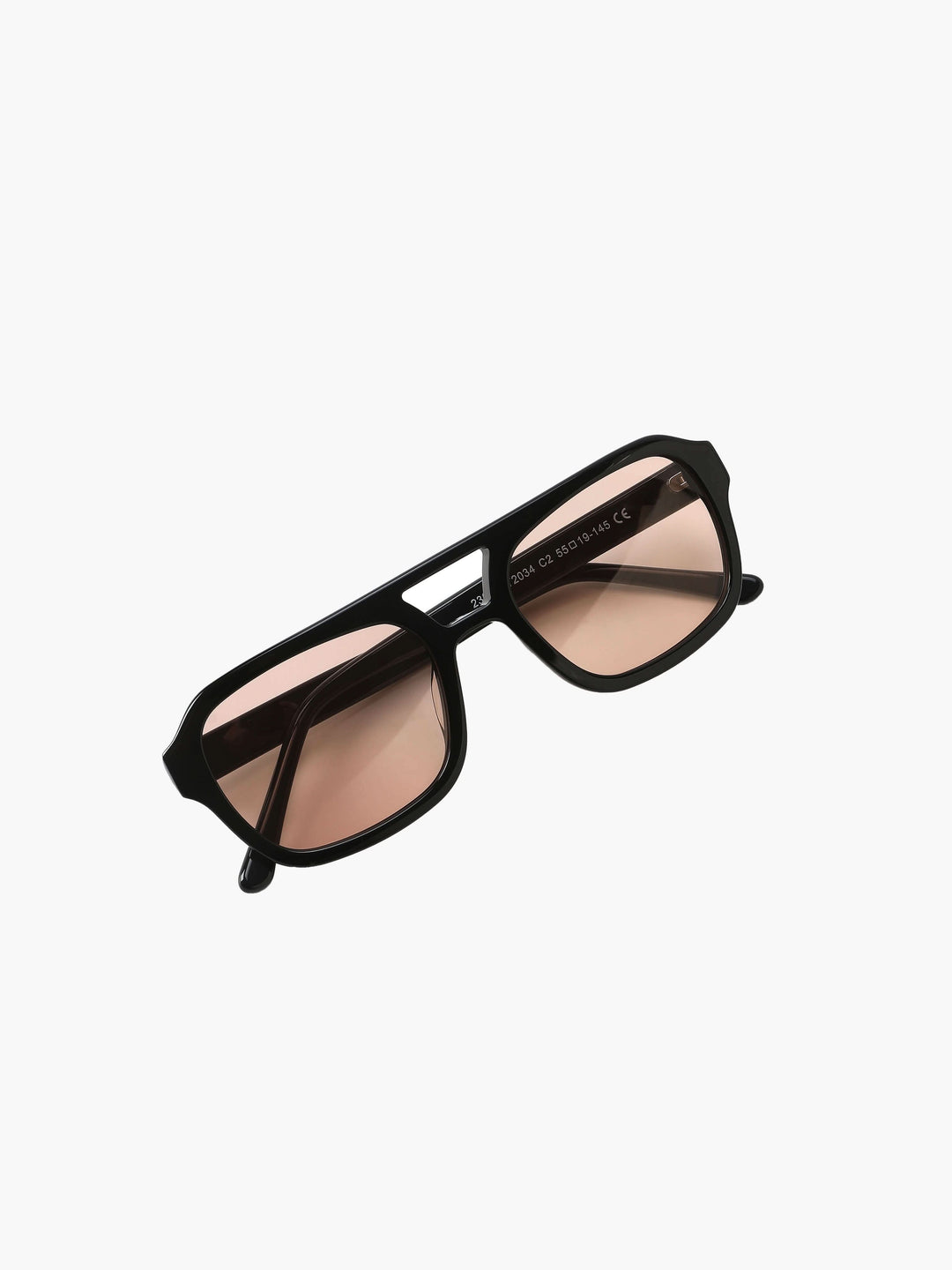 A woman wearing two-tone oval vintage sunglasses on a sunny day outdoors.