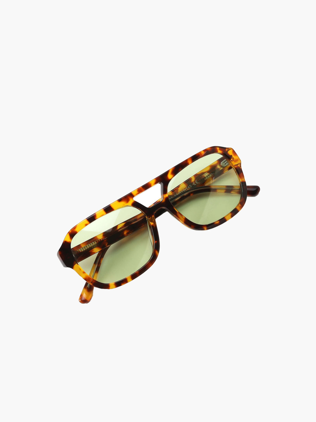 A woman wearing two-tone oval vintage sunglasses on a sunny day outdoors.