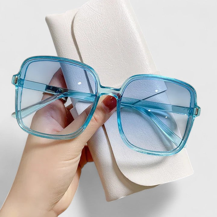 A woman wearing vintage-inspired oversized sunglasses in the sun, elegant and relaxed.