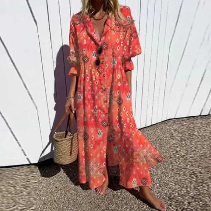 Woman wearing the Zara™ leaf print maxi dress with a button front, walking along the coast in a light breeze.