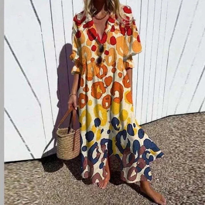 Woman wearing the Zara™ leaf print maxi dress with a button front, walking along the coast in a light breeze.