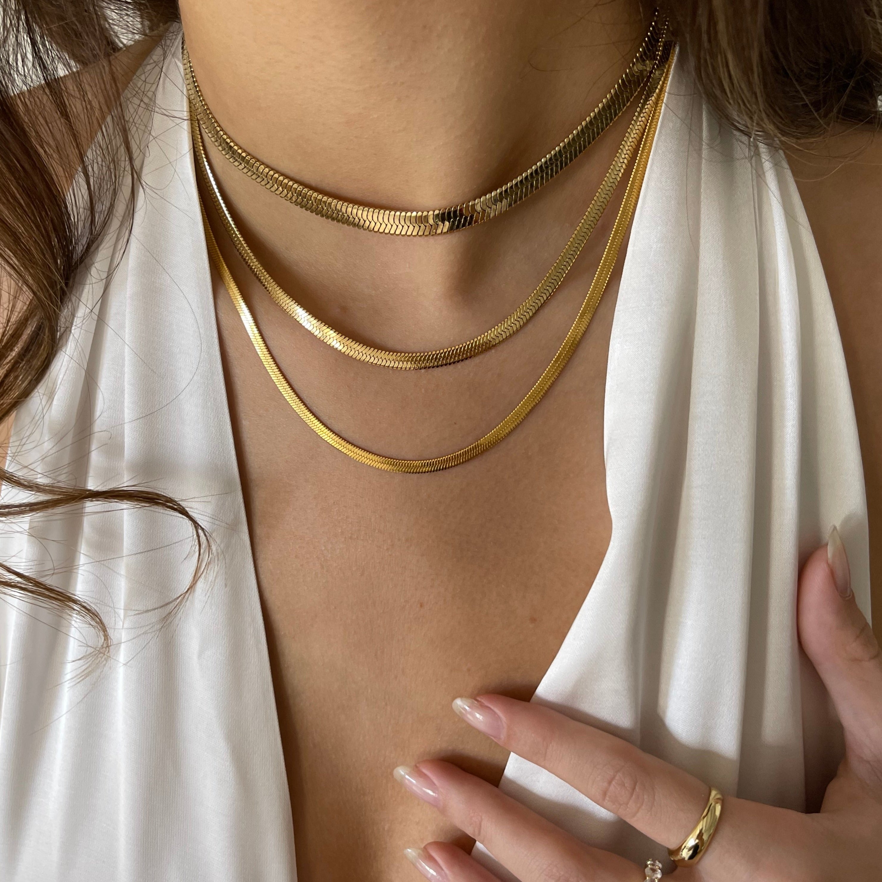 Gold snake pendant necklace with gleaming sculptural finish