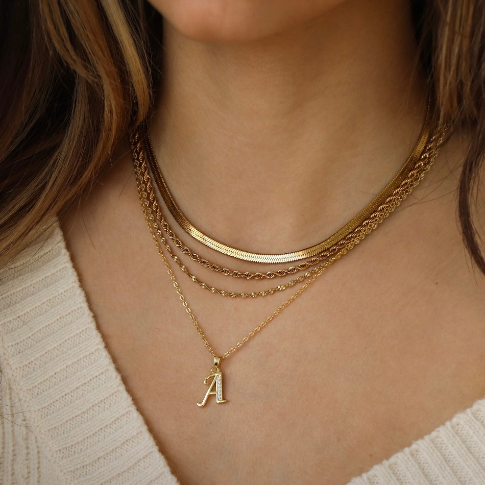 Gold snake pendant necklace with gleaming sculptural finish