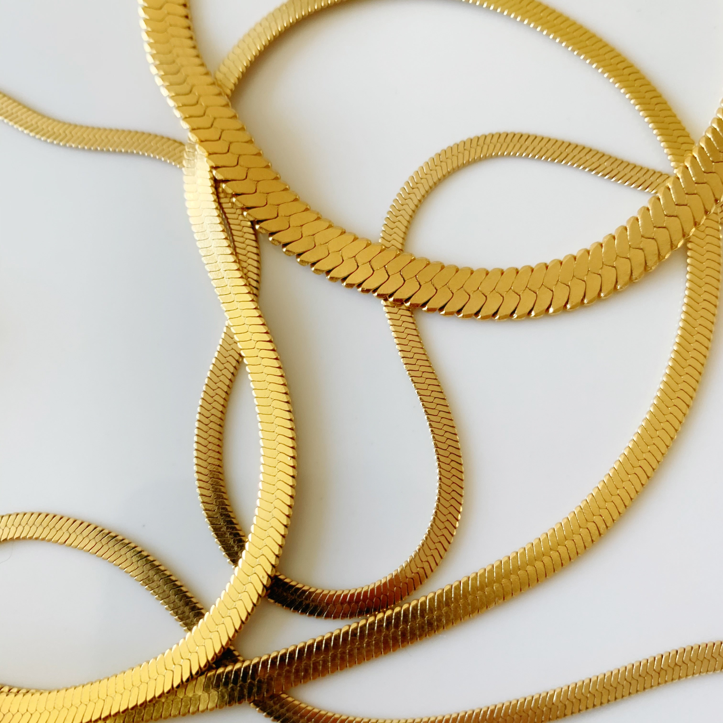 Gold snake pendant necklace with gleaming sculptural finish