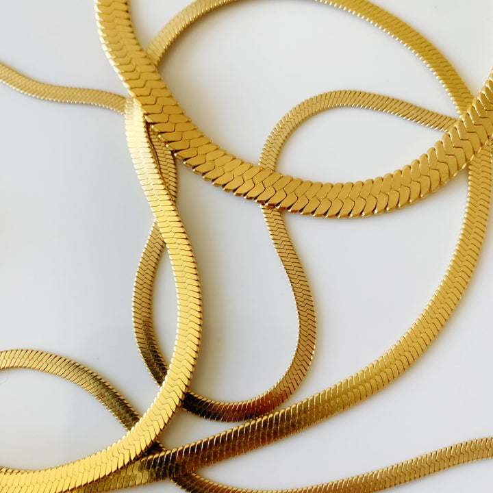 Gold snake pendant necklace with gleaming sculptural finish