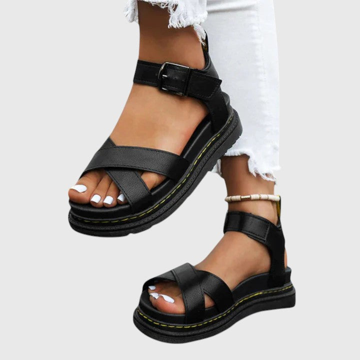 A woman walking confidently in elegant wide-fit orthopaedic sandals with buckle straps.