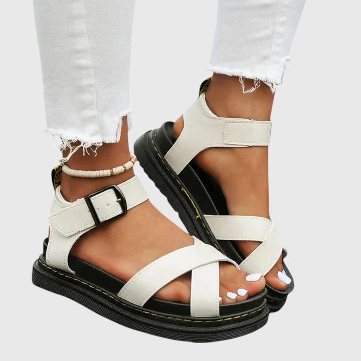 A woman walking confidently in elegant wide-fit orthopaedic sandals with buckle straps.