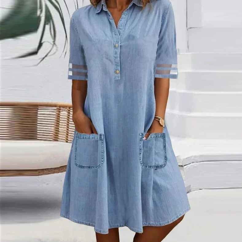 Woman wearing the Emily blue button-collar dress with front pockets, strolling through town.