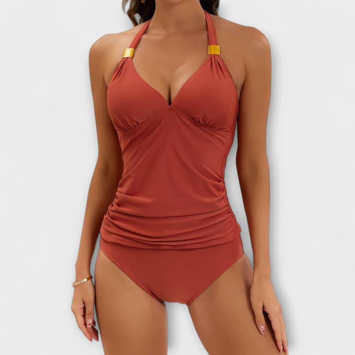 A woman by the water in a lively printed two-piece swimsuit, relaxed and confident in the sun.