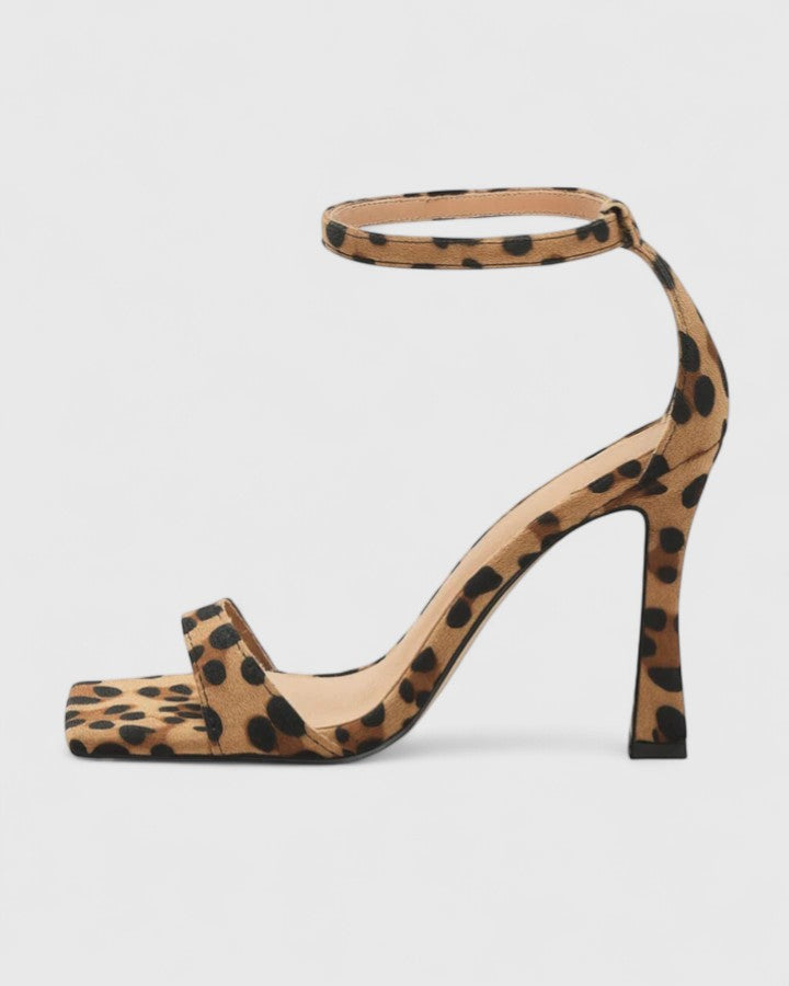 A woman wearing leopard-print heels with an ankle strap on a night out.