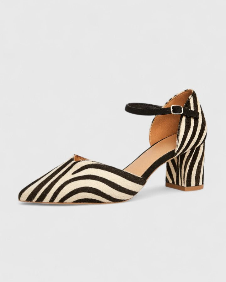A woman wearing khaki block-heel sandals with an adjustable ankle strap and open design.