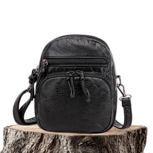 A woman carrying a simple black everyday handbag on her shoulder on a relaxed day out.