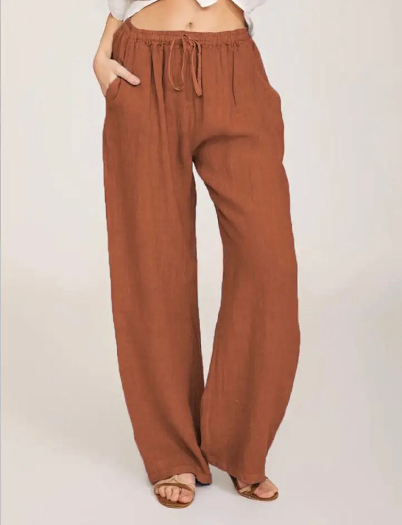 Woman wearing lightweight summer trousers with a light blouse, walking on a warm day.