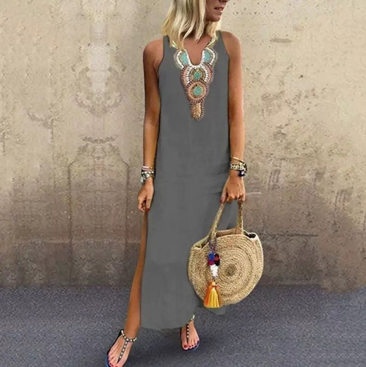 Woman in a sleeveless midi dress with embroidered neckline strolling in the summer sun.