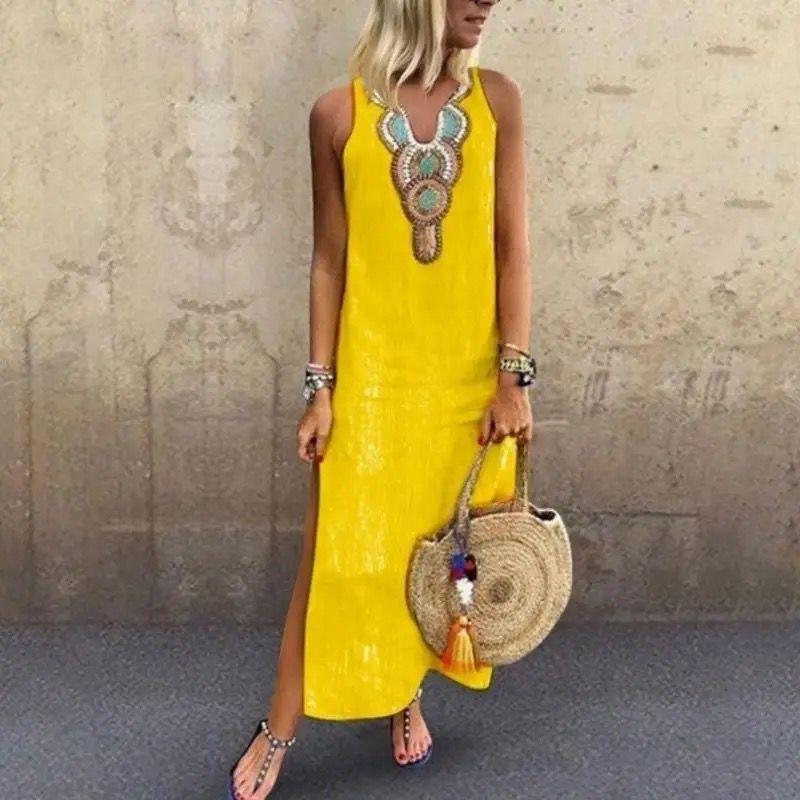 Woman in a sleeveless midi dress with embroidered neckline strolling in the summer sun.
