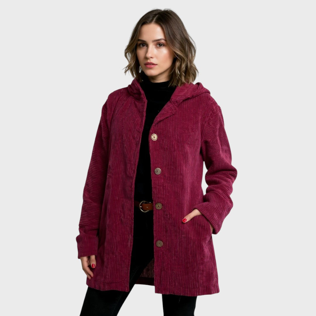 A woman wearing a hooded textured jacket outdoors in autumn