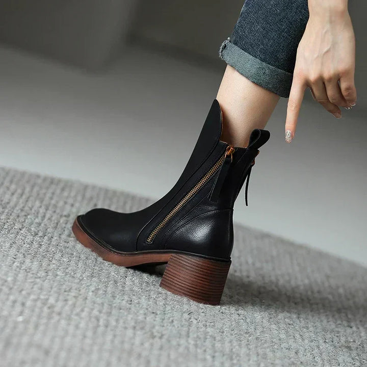 A pair of classic black ankle boots with a sturdy block heel and side zip fastening