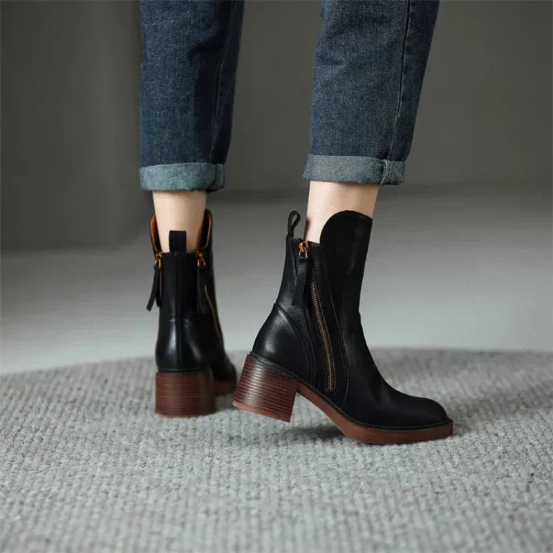 Black minimalist ankle boots with a sturdy block heel and side zip fastening