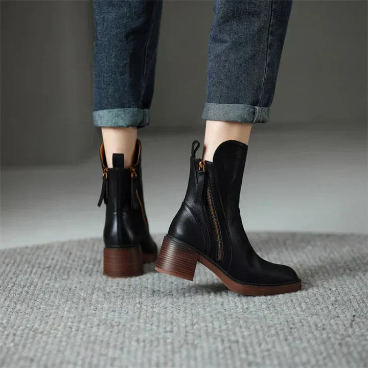 A pair of classic black ankle boots with a sturdy block heel and side zip fastening