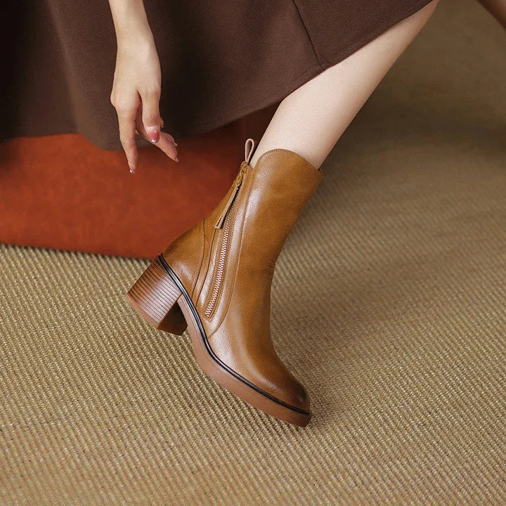 Black minimalist ankle boots with a sturdy block heel and side zip fastening
