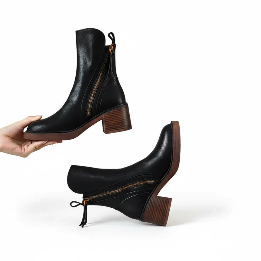 Black minimalist ankle boots with a sturdy block heel and side zip fastening