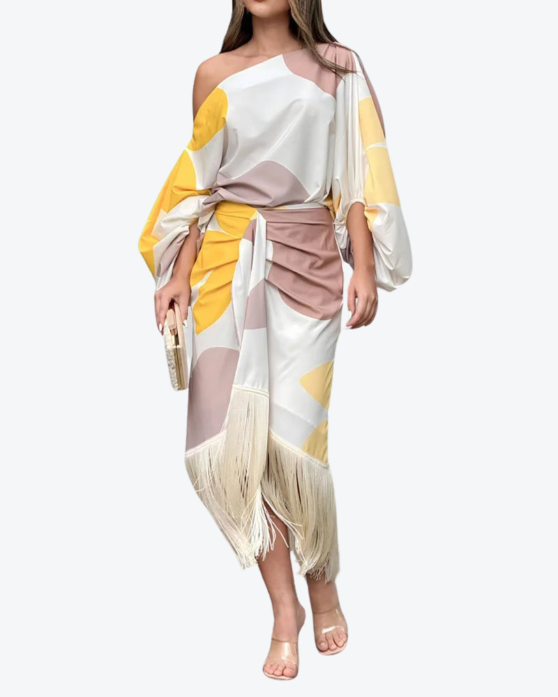 A woman wearing a bold-print one-shoulder two-piece set with a flowing hem