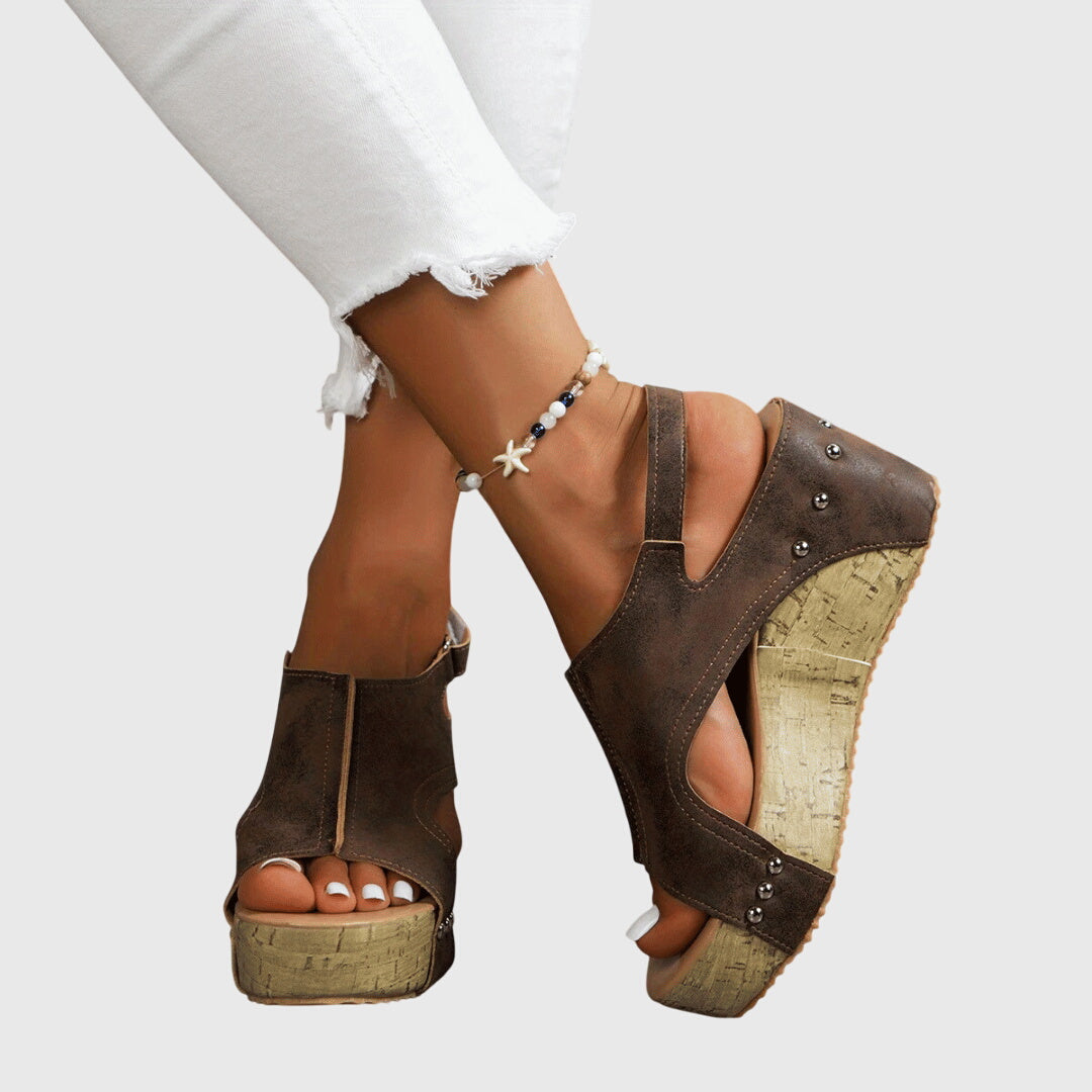 A woman in studded wedge sandals with an open front at a summer event.
