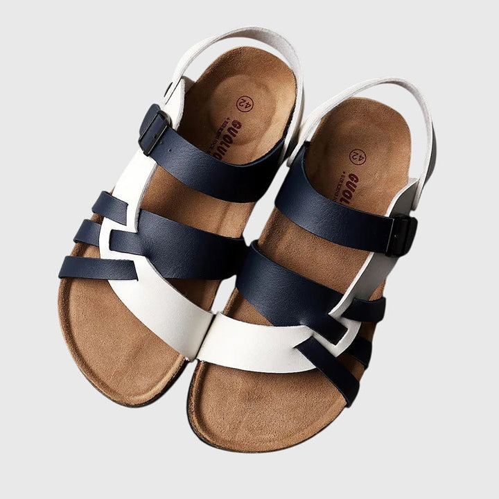 A woman in colourful cross-strap summer sandals with an adjustable ankle buckle on a warm day.