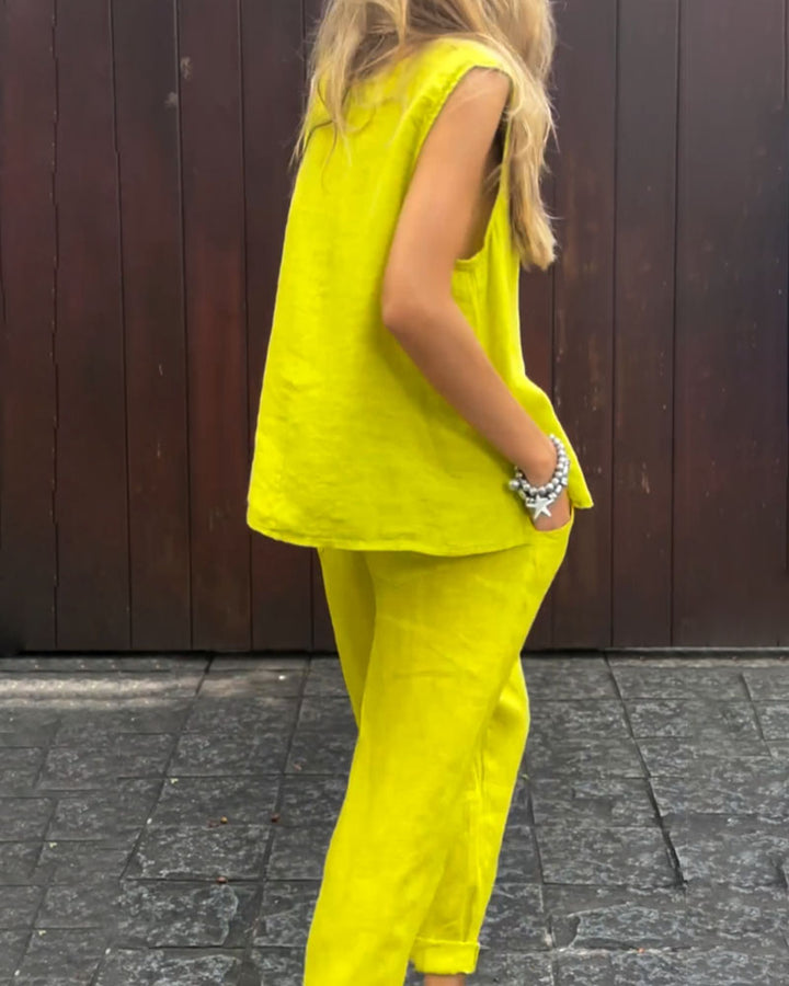 A woman wearing a relaxed sleeveless top with ankle-length trousers, easy and elegant.