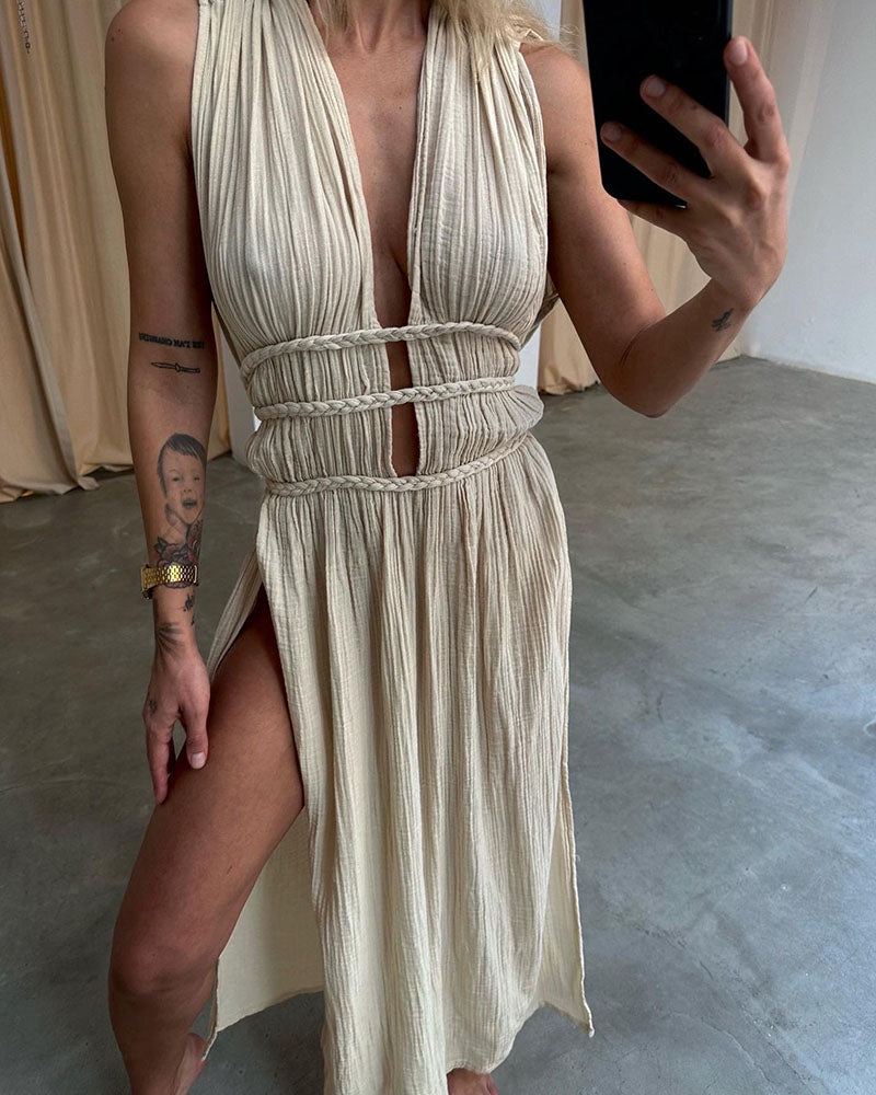 Woman in a softly textured dress with front slit and cinched waist tie at golden hour.