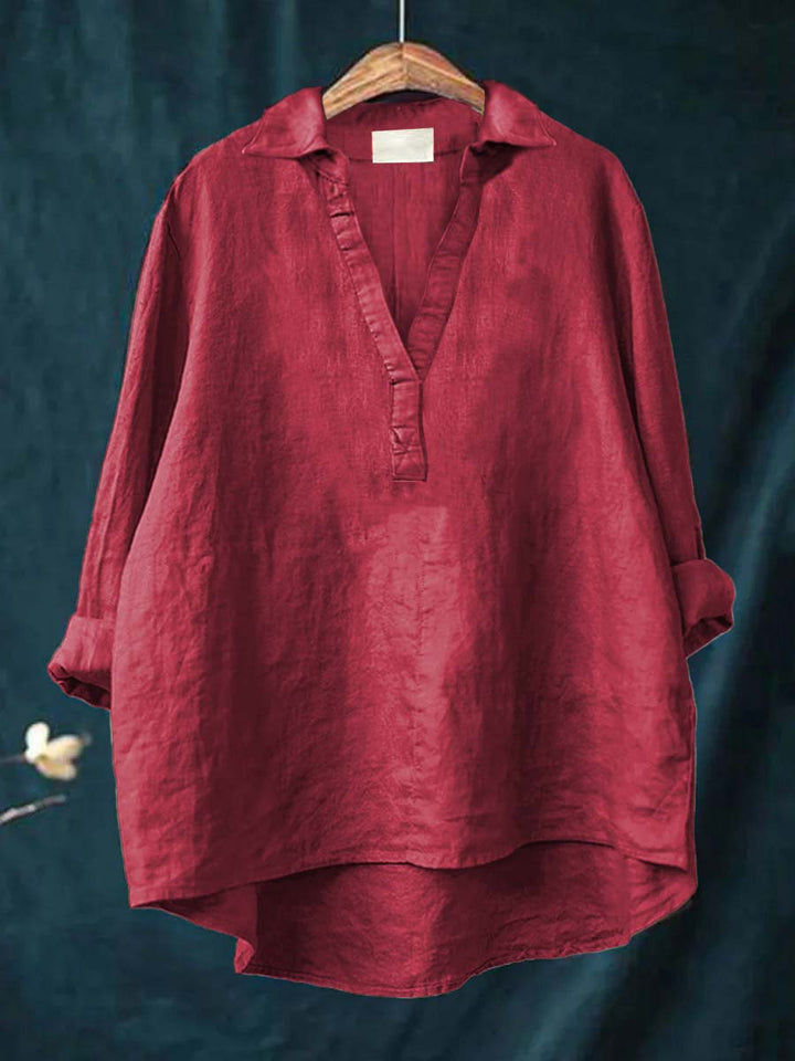 A woman wearing an elegant solid-colour summer blouse with an open V-neck, looking fresh and stylish on a warm day.