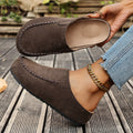 A pair of minimal slip-on loafers in warm brown with a soft footbed and open back