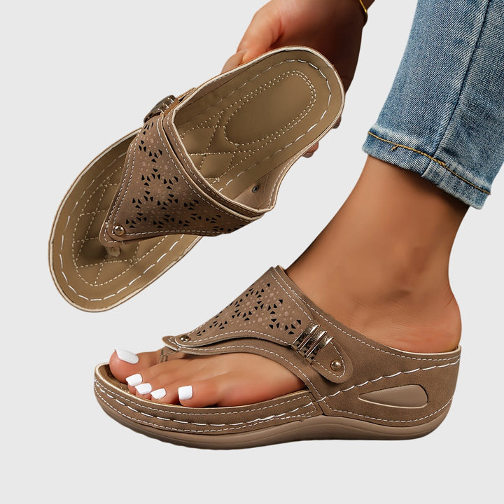 A woman in grey comfort flip-flops relaxing outdoors, feet cushioned and supported.