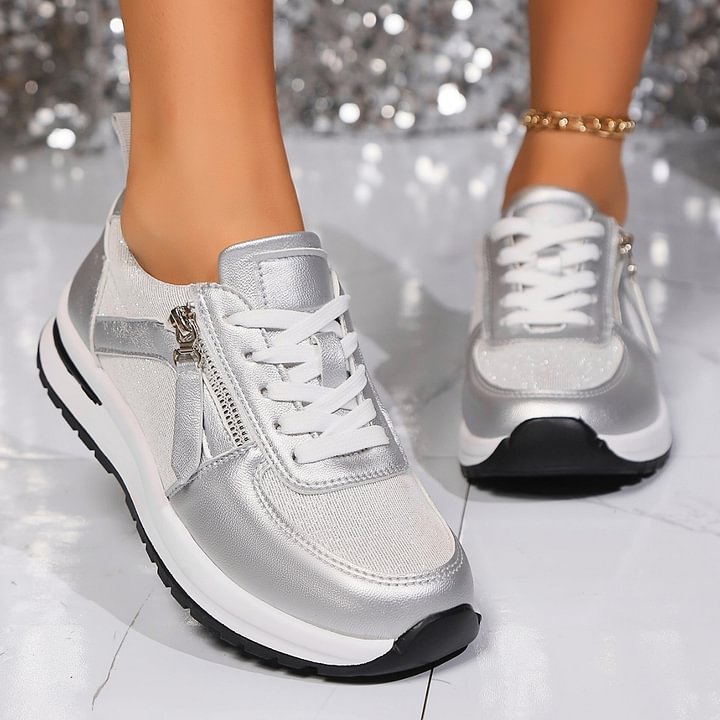 A woman in silver orthopaedic trainers with a handy side zip.